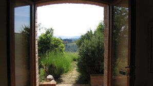 An open doorway leading to a garden with a stone pathway and greenery.