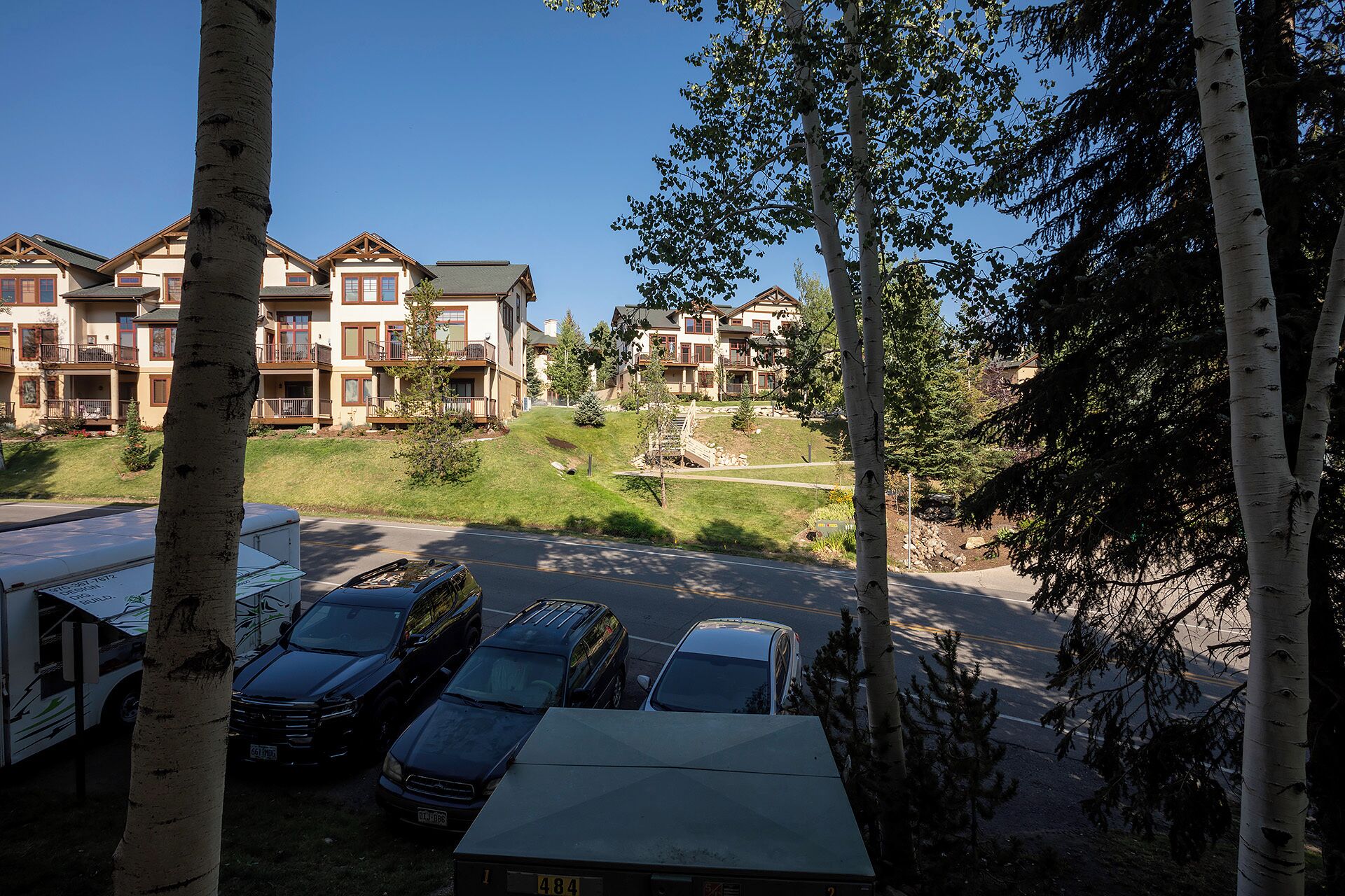 A residential area with multi-story houses, a parking lot, and a small bridge.