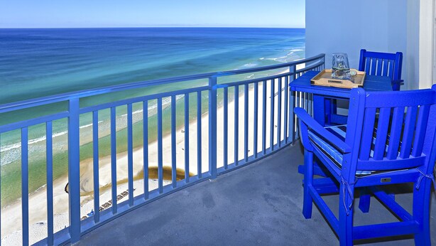 Un balcon avec vue sur la plage et l’océan.
