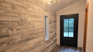 A hallway with wooden paneling, a black door, and a window. -
Ski-In/Ski-Out Killington Chalet - Hot Tub, Fireplace & Views (Killington)