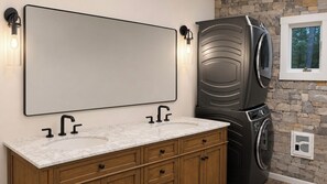 A bathroom with a double sink vanity, a large mirror, and a built-in washer and dryer. -
Ski-In/Ski-Out Killington Chalet - Hot Tub, Fireplace & Views (Killington)