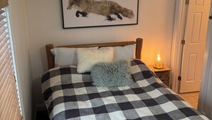 A bedroom with a checkered bedspread, a fluffy pillow, and a framed animal print on the wall. - 

Ski-In/Ski-Out Killington Chalet - Hot Tub, Fireplace & Views (Killington)