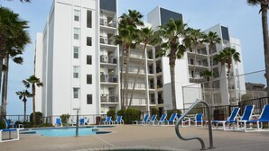 A hotel with a pool area, including lounge chairs and a hot tub. - Beachfront condo: Create some memories! (South Padre Island)