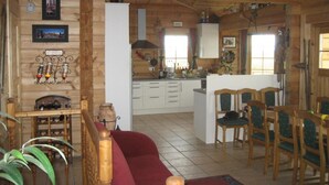 Ein gemütliches Blockhaus-Interieur mit Wohnbereich, Küche und Essbereich.