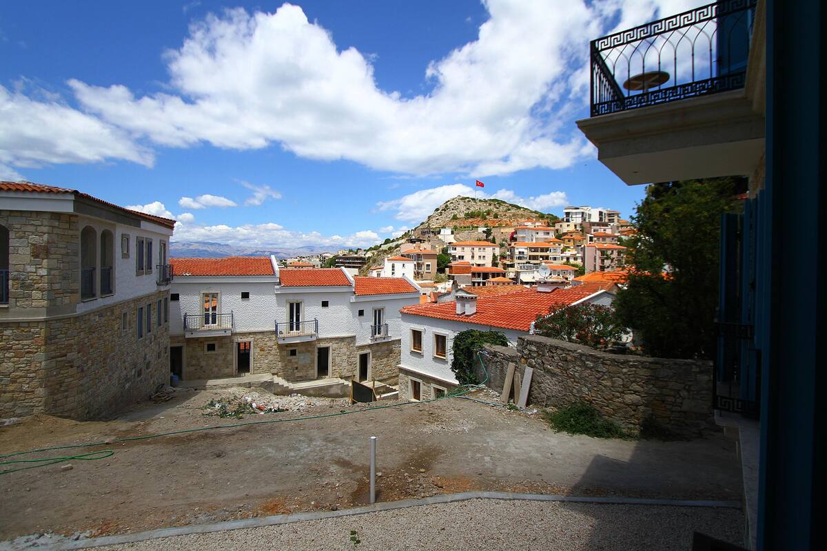 A view of a hillside town with stone buildings and red-tiled roofs.