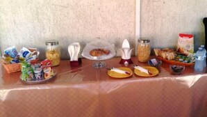 A breakfast buffet table with various food items and condiments. - Olympus B&B (Agrigento)