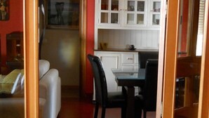 A compact living space with a dining area, a kitchenette, and a sofa. - Olympus B&B (Agrigento)