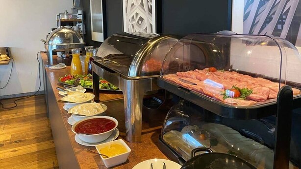 A buffet setup with various food items and condiments. - Zaliasis slenis - Self check-in hotel (Aukštkiemiai)