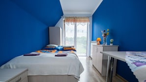 Un dormitorio con cama, escritorio y vistas a un balcón.