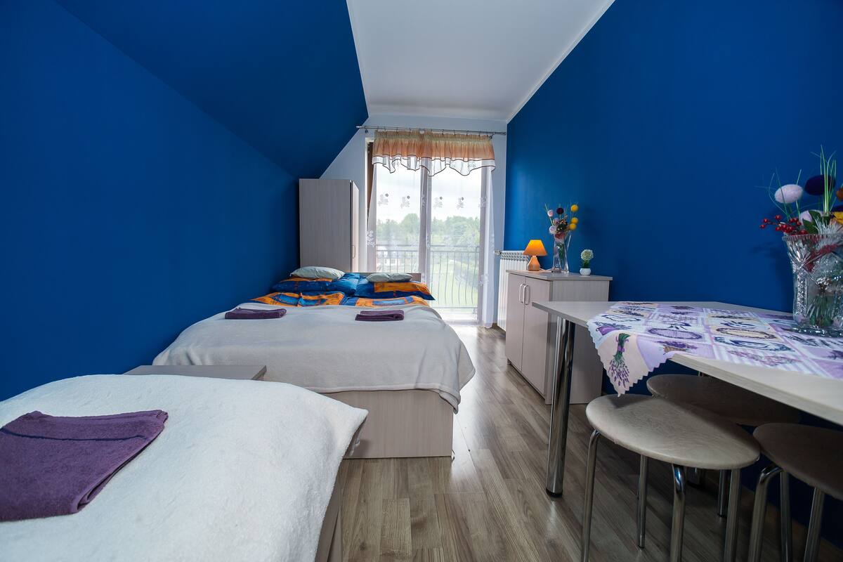 Ein Schlafzimmer mit zwei Betten, einem Schreibtisch und Blick ins Freie.