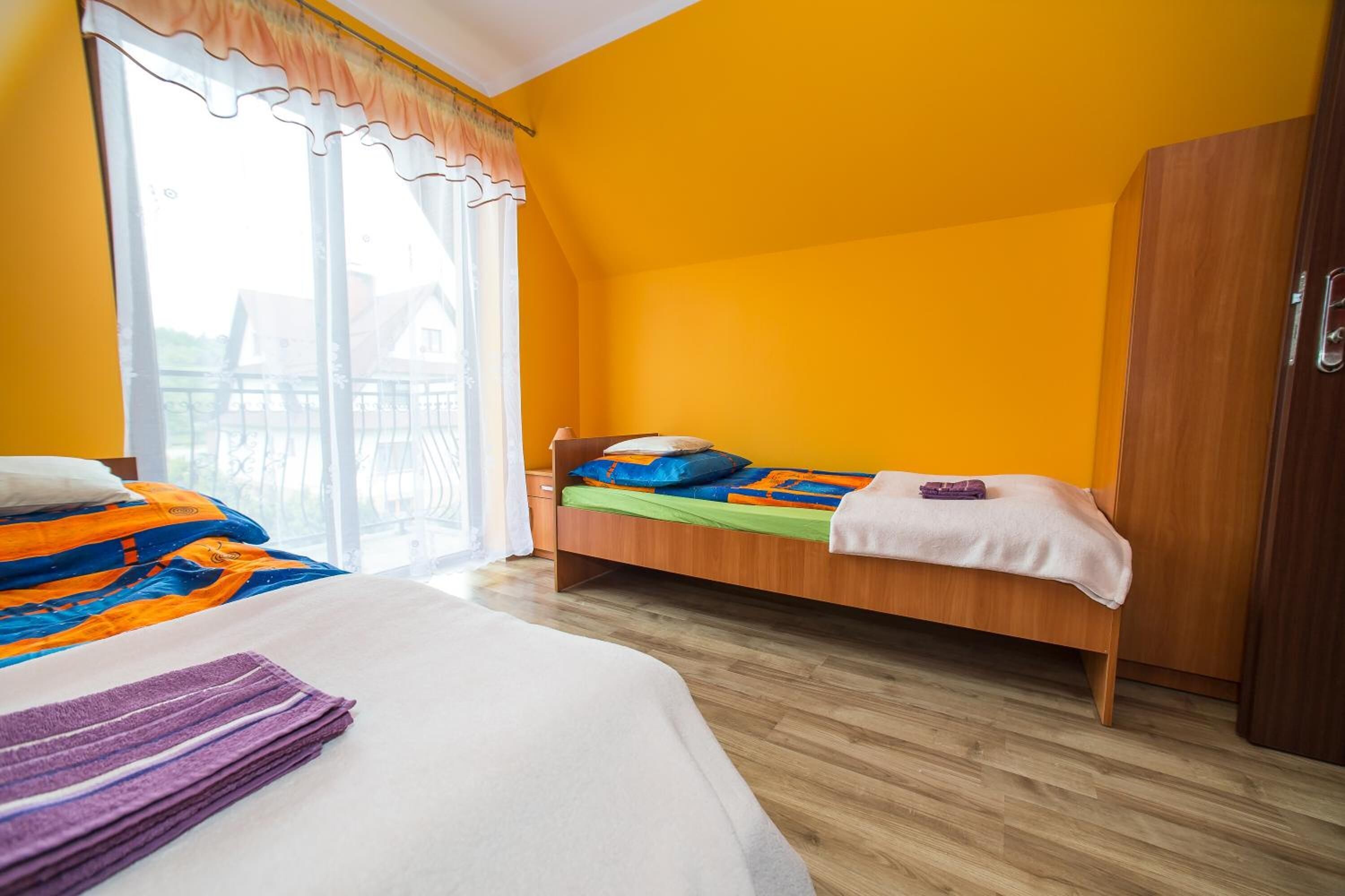 Une chambre avec un lit, une armoire et une fenêtre avec des rideaux.
