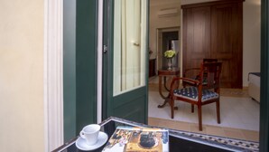 A room with a dining area, a wooden cabinet, and a table with a white cup and saucer.