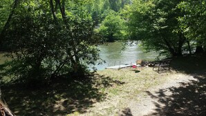 A lakeside park with a bench and a picnic table.