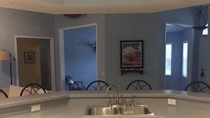Una cocina moderna con lavavajillas integrado, armarios blancos y una pared de acento azul.