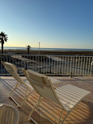 Una terrassa amb gandules davant d'una platja.