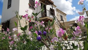 A two-story building with a balcony and a stone base. - Olympia Traditional Houses (Lympia)