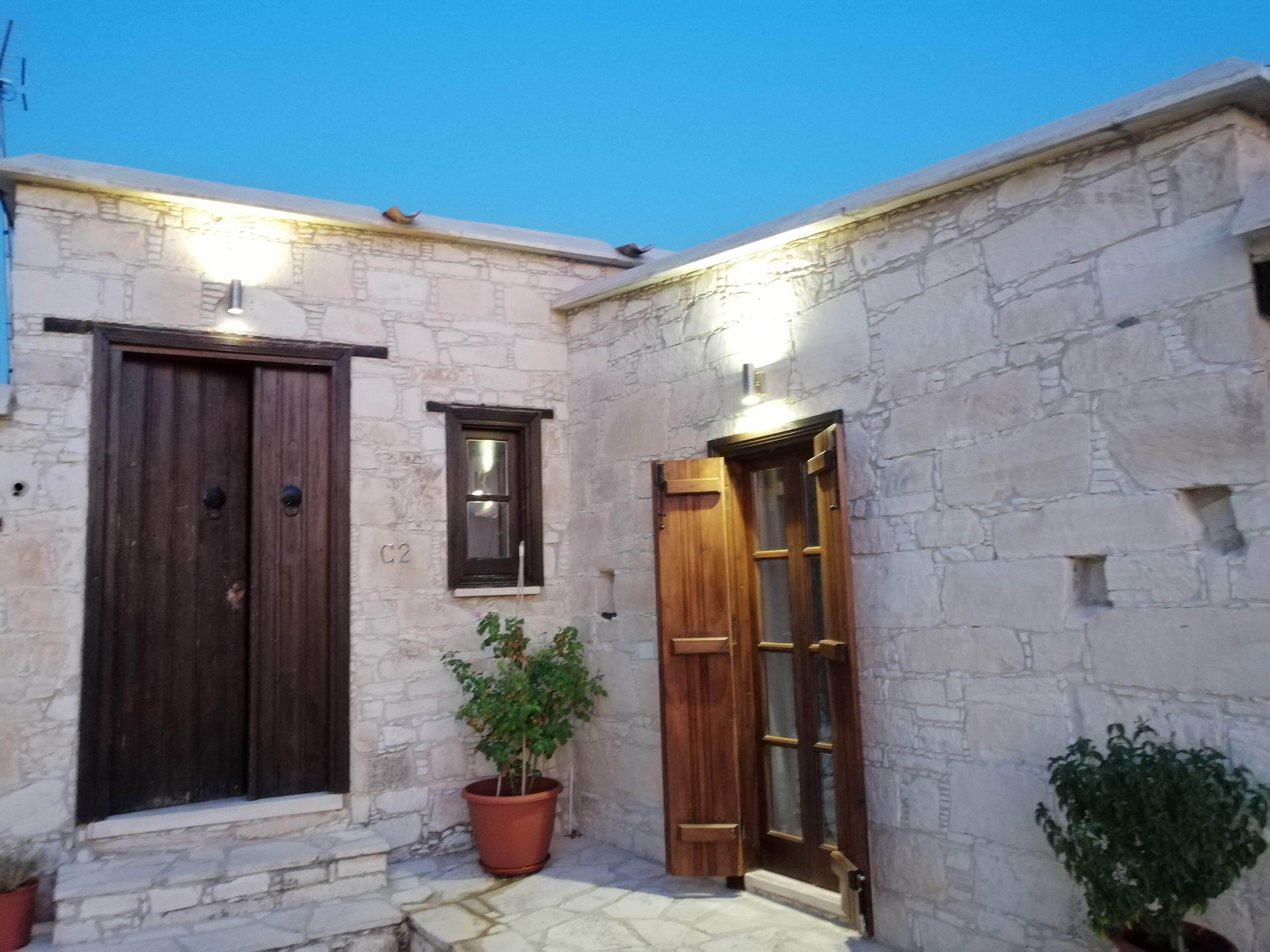 A stone building with a dark wooden door and a window.