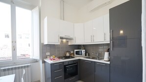 A modern kitchen with white cabinets, a black oven, a microwave, and a refrigerator. - The emotion of living in a Renaissance palace in the heart of Florence (Firenze)
