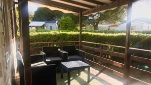 Un patio techado al aire libre con muebles de mimbre y una mesa.