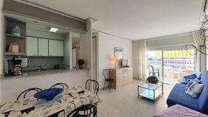 A compact living space with a kitchenette, dining area, and a sofa. - Blaumar B38 Estartit apartment rental with pool and air conditioning (Estartit)