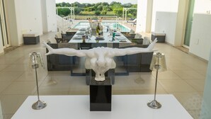 Un comedor con una mesa central, dos sillas y una escultura decorativa.
