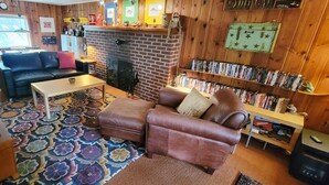 Una sala de estar acogedora con chimenea, un sofá, una mesita de centro y una estantería llena de libros.