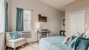 Une chambre à coucher avec un lit, une chaise, un bureau et une fenêtre.