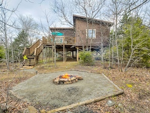 A cabin with a fire pit in the yard, surrounded by trees. - Romantic Woods Escape with Oversized Deck (Stigler)