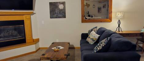 A living room with a fireplace, a television, a sofa, and a coffee table.