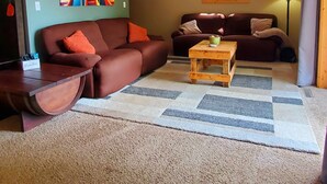 A living room with two sofas, a coffee table, a painting, and a lamp. - Escape to Tranquility on Ross Lake: A Perfect Getaway! (Aitkin)