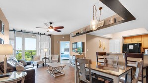 A spacious living area with a dining table, chairs, a sofa, and a ceiling fan. - 🌴Palms 2416- Beach Nearby+Lagoon Pool⛱️ (Destin)