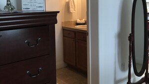 A bathroom with a wooden dresser, a framed picture on the wall, and a mirror. - Tranquil Lakefront Setting near Clemson SC with Private, Covered Dock (Seneca)