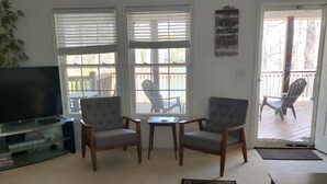 A living room with a TV, two armchairs, a coffee table, and a rug. - Tranquil Lakefront Setting near Clemson SC with Private, Covered Dock (Seneca)