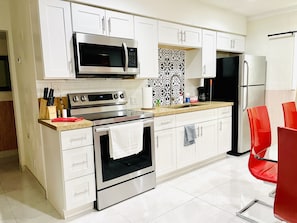 Enjoy cooking in this well-equipped kitchen with stainless steel appliances, a microwave, oven, and refrigerator, along with a sink and cabinetry.