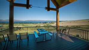 Un espacio al aire libre techado con una mesa y sillas de picnic, con vistas a un paisaje pintoresco.