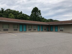 A motel with a row of rooms, each with a door and a window.