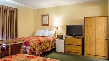 A hotel room with a bed, a TV, a desk, and a wardrobe.