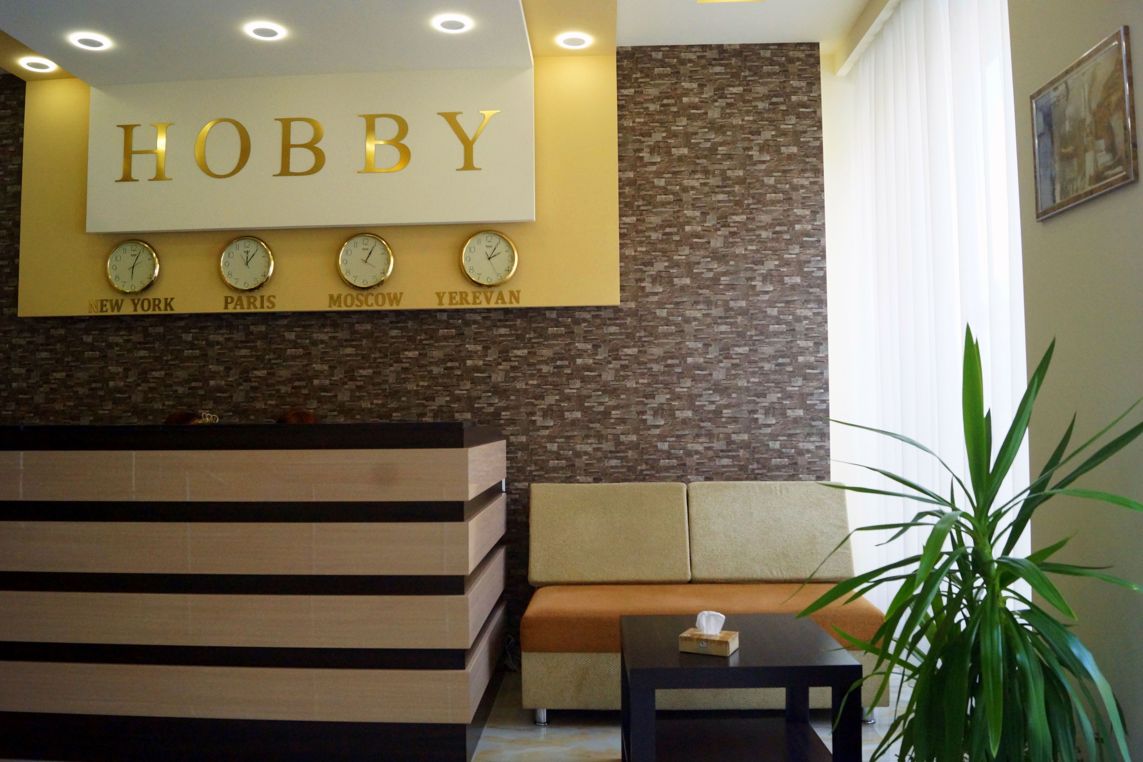 A reception area with a sign reading "HOBBY" and clocks indicating time in New York, Paris, Moscow, and Yerevan.