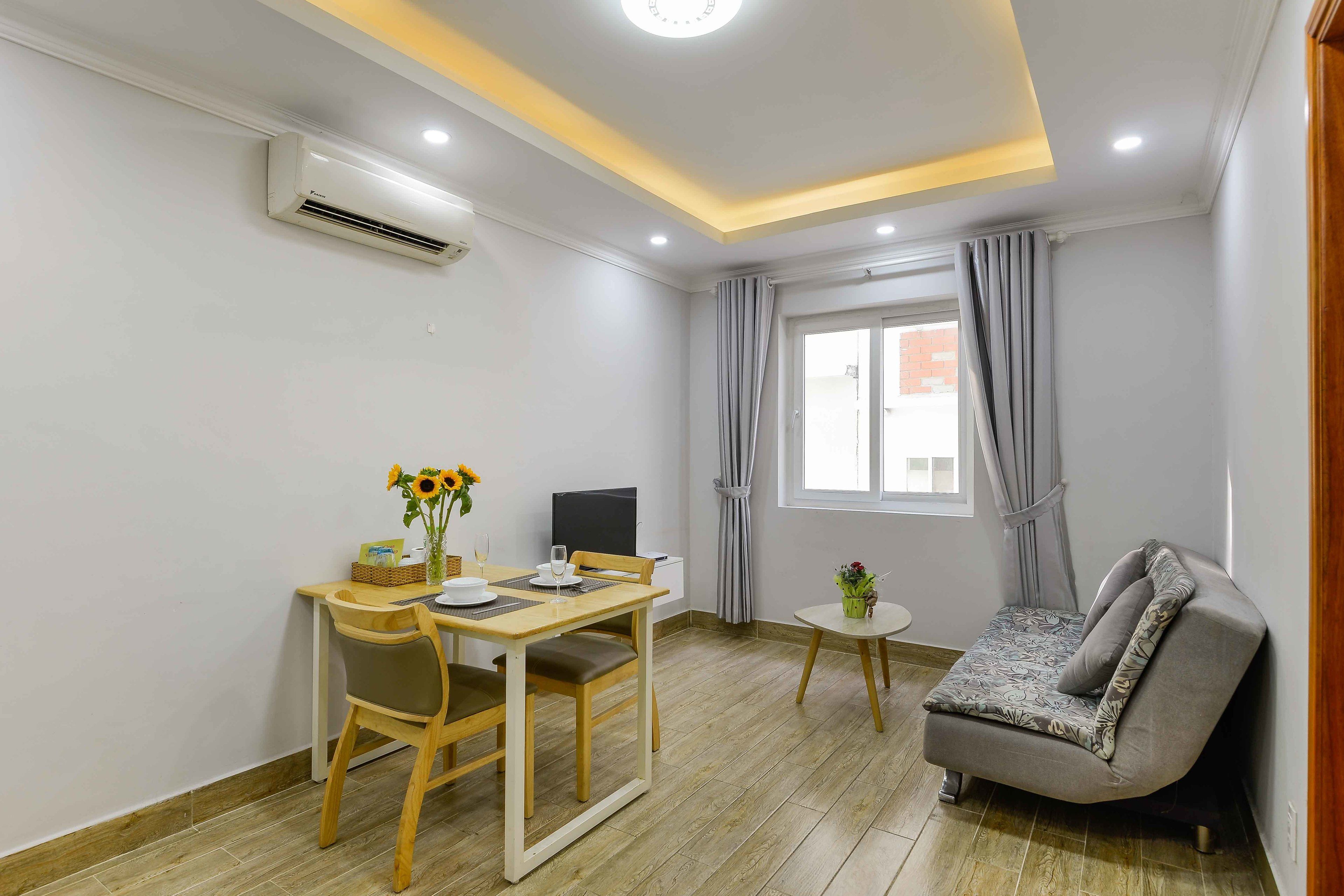 Une pièce moderne comprenant une table à manger, des chaises, un canapé et un téléviseur.