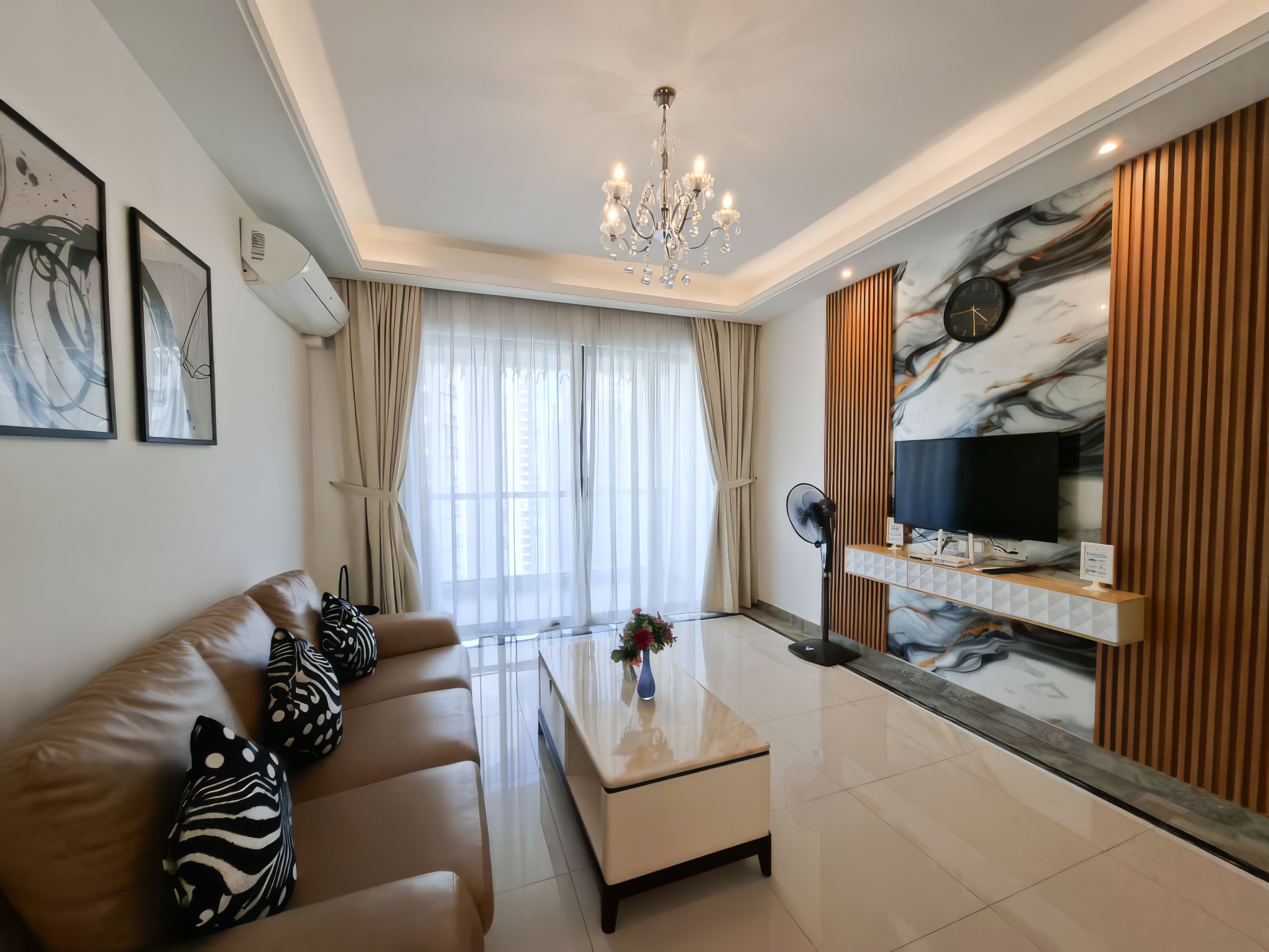 A modern living room with a sofa, coffee table, and a TV mounted on a wall with a marble design.
