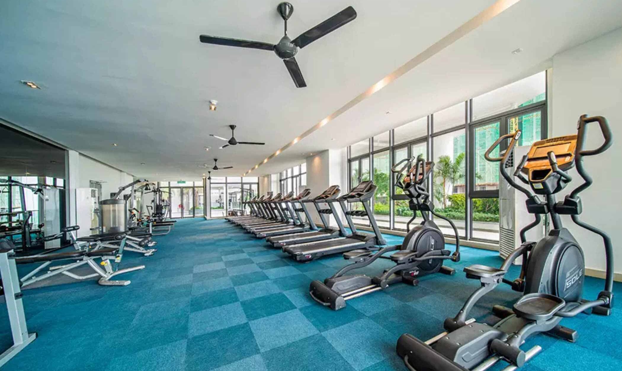 A gym with treadmills, elliptical machines, and free weights.