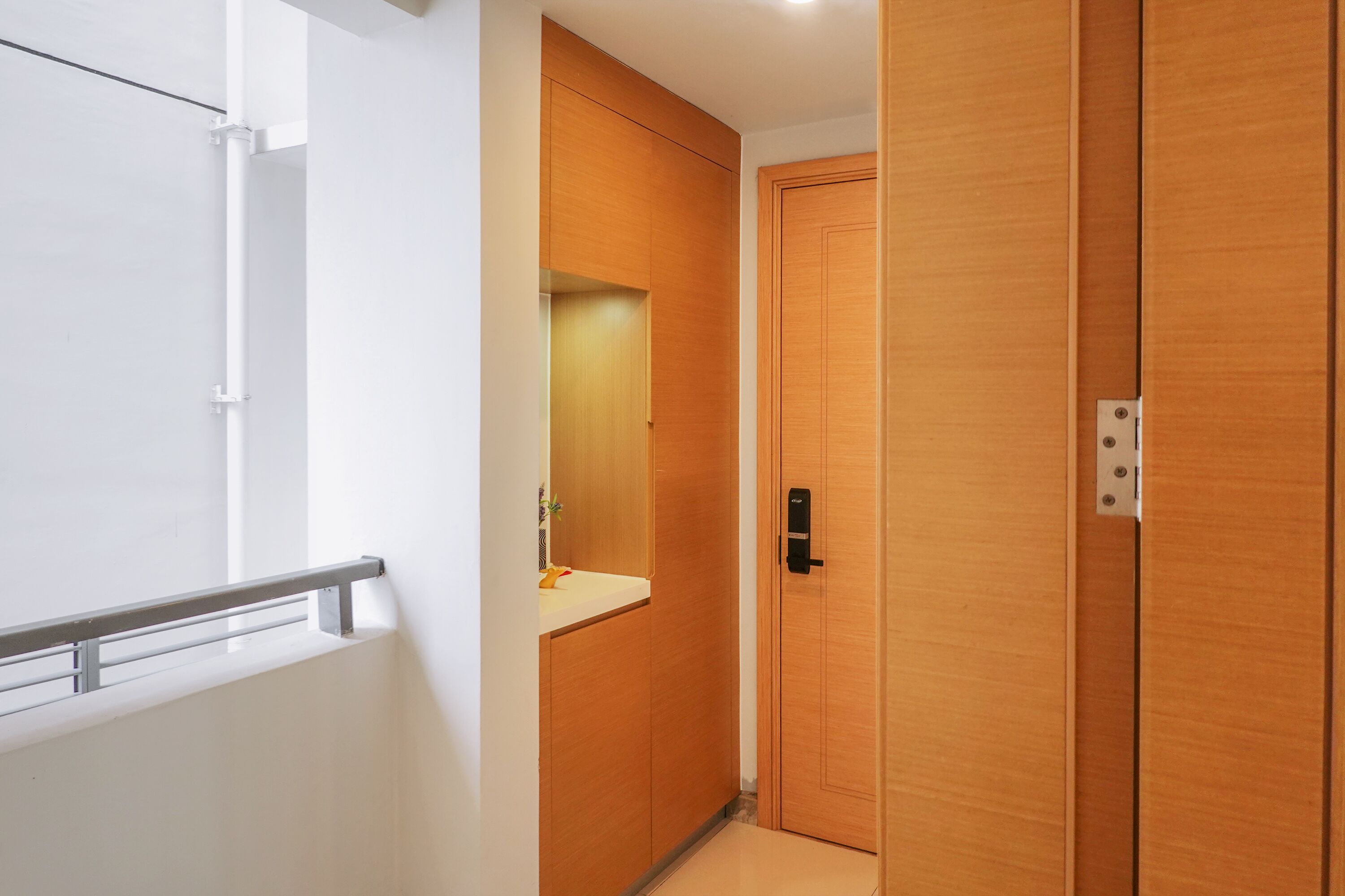 A modern bathroom with a wooden vanity, a mirror, and a door with a handle.