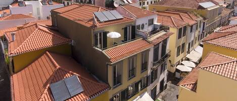 Un edificio de gran altura con varios balcones y paneles solares.