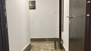 A hallway with a mosaic floor, a welcome mat, and a door with a metal handle. - DayDream (Pomorie)