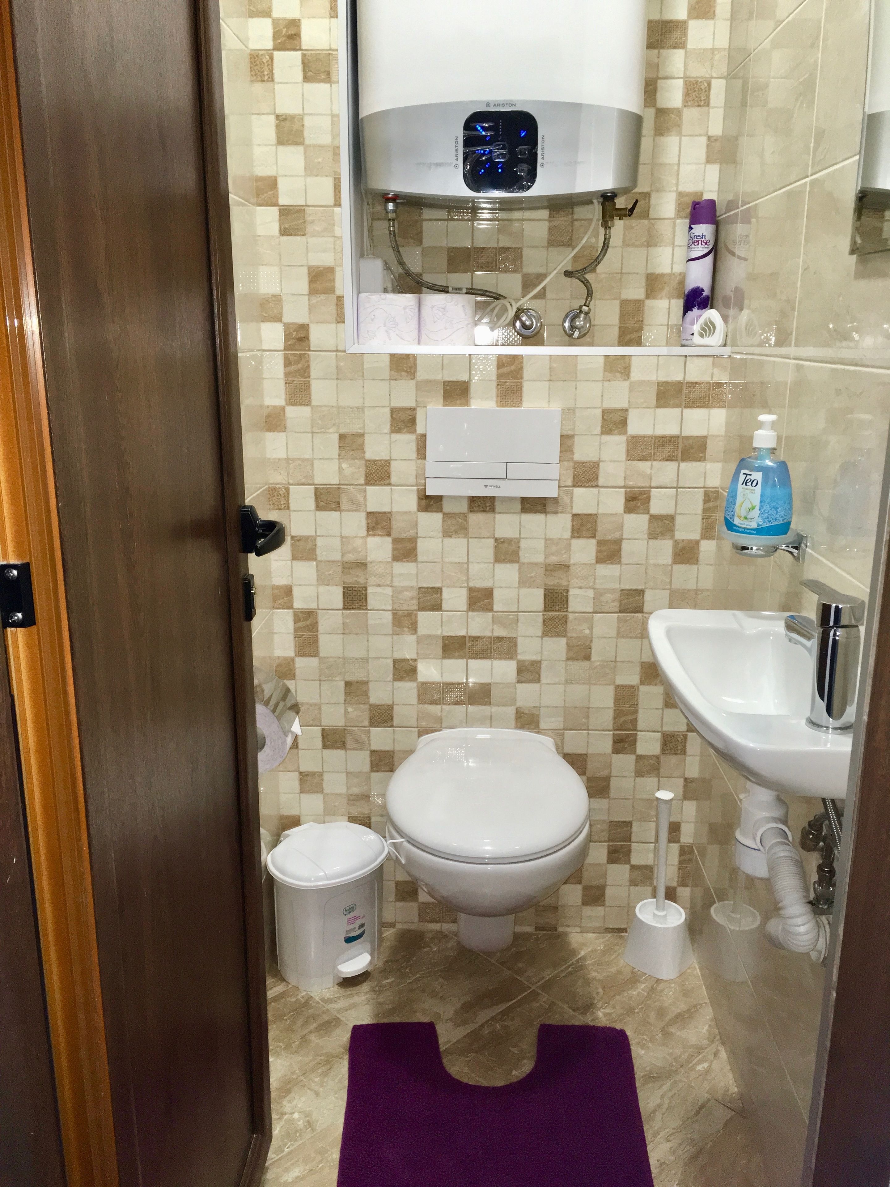 A bathroom with a toilet, bidet, sink, and a shower area.