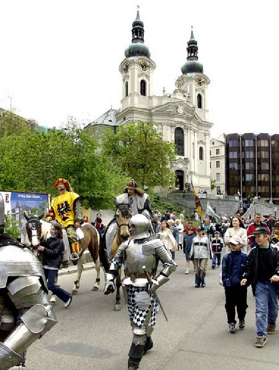 Ein historisches Gebäude mit zwei Türmen, die mit Kuppeln gekrönt sind, und einem Uhrturm.