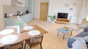 Un appartement moderne comprenant un coin repas, une cuisine, un salon et un téléviseur.