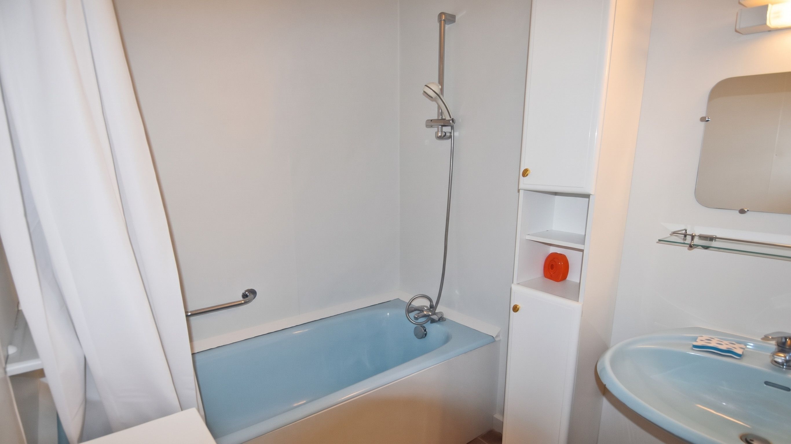 A bathroom with a bathtub, a shower, a sink, and a mirror.