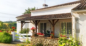 A house with a covered porch, stone wall, and a white fence. - Homerez - House in Lannes, terrace & garden (Lannes)