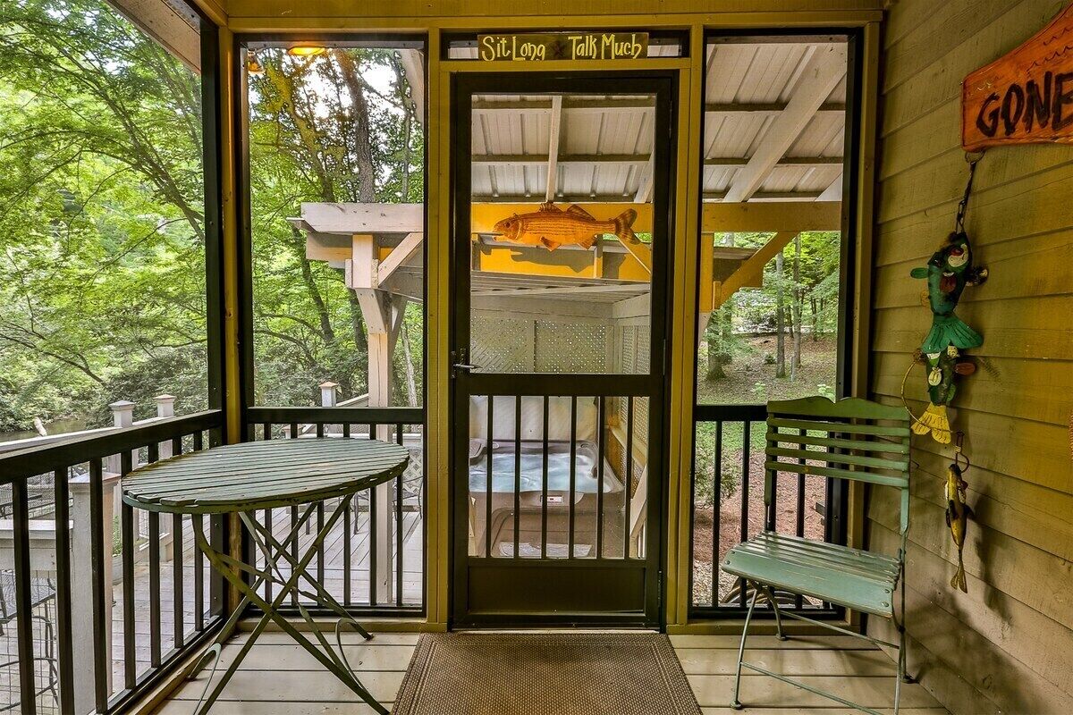 A porch with a bench, a table, a fish hanging on the wall, and a sign that says 'Gone'.